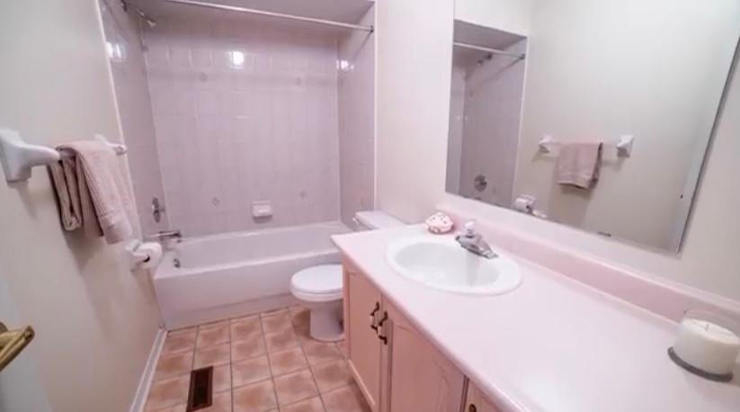 Before: Builder-Grade Bathroom - Aurora ON. Original bathroom with dated tub surround, vanity, and flooring prior to renovation.