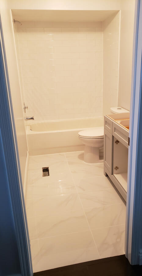 After: Updated Bathroom Finishes - Aurora ON. Refreshed tub surround, new flooring, and updated vanity for a cleaner modern look.